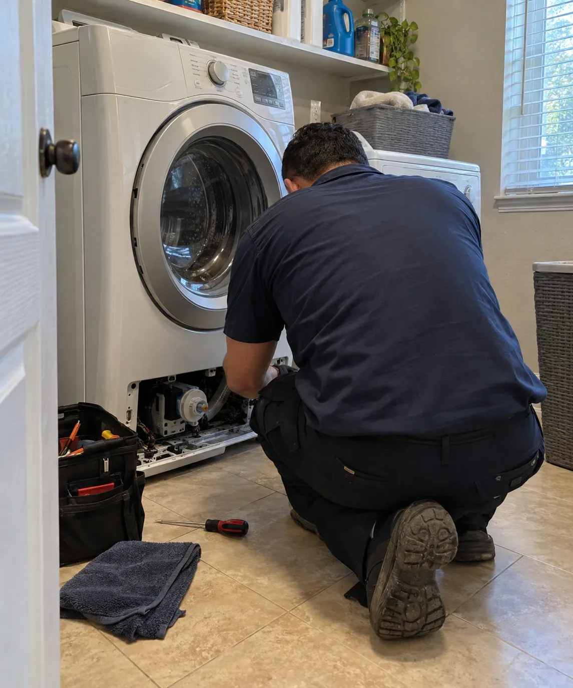 Appliance repair technician at work in a Grand Prairie, TX home